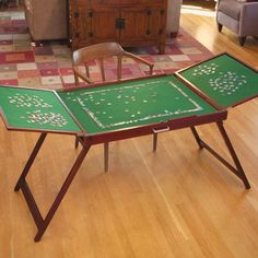 a green table sitting on top of a hard wood floor next to a brown chair