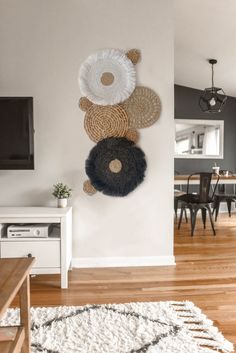 a living room with white walls and wooden flooring next to a tv mounted on the wall