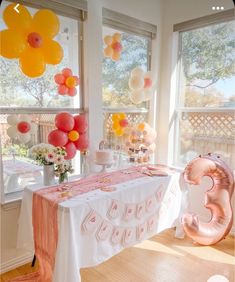 a table with balloons and cake on it