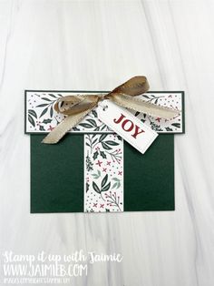 a handmade christmas card with the word joy on it and a ribbon tied around it