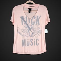 a pink t - shirt that says rock music with an eagle and guitar on it