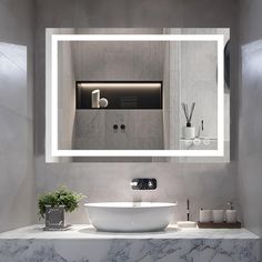 a bathroom sink sitting under a mirror in front of a wall mounted faucet