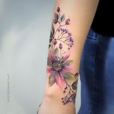 a woman's arm with a flower tattoo on the left side of her arm