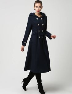 "This beautiful long wool coat features a double-breasted bodice and oversized silver buttons to create a distinct but classic military style. this winter coat features gorgeous navy blue wool, a polyester lining, and fun features like extra long sleeves, deep side pockets and back split vents. The self-tie belt makes it easy to accentuate your waist while the warm hood will stylishly shield you from the cold. DETAIL * 50% WOOL,50% POLYESTER * POLYESTER LINING * Epaulette with button * with warm Hooded Pea Coat For Workwear, Hooded Pea Coat With Buttons For Workwear, Winter Double-breasted Wool Coat With Button Closure, Elegant Blue Wool Coat With Buttons, Blue Double-breasted Wool Coat With Button Closure, Spring Long Peacoat With Buttons, Spring Peacoat With Buttons, Winter Long Coat Peacoat With Double-breasted Buttons, Winter Long Peacoat With Double-breasted Buttons