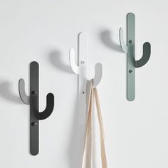 three hooks are hanging on the wall next to each other