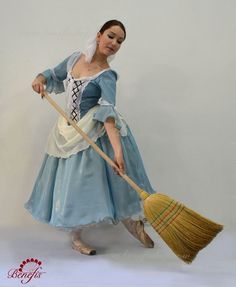 a woman in blue dress holding a broom