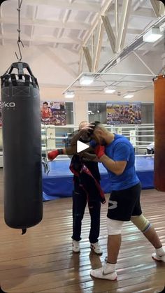 two people in a boxing ring with punching gloves