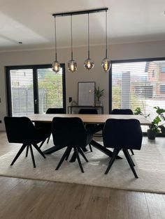 a dining room table surrounded by black chairs