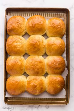 freshly baked bread rolls in a baking pan on a marble counter top, ready to go into the oven