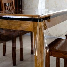 a glass table with wooden chairs around it