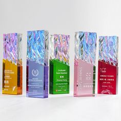 four different colored glass blocks with silver foil on them and one is red, green, blue, yellow or pink