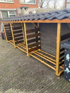 a row of wooden benches sitting next to each other on top of a brick sidewalk