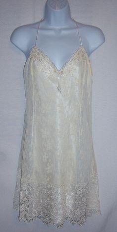 "Vintage Flora Nikrooz ivory satin and lace bridal or honeymoon teddy nightgown, negligee, peignoir or gown. Deadstock. Never worn. Original tags still attached. Women's size LARGE. 100% polyester. Measurements: bust-40\", length-37\", waist-32\". All lace body with satin lining. Gorgeous lace hem." Sleeveless Cream Nightgown For Wedding, White Lace Nightgown For Wedding Night, Sleeveless Lace Trim Chemise For Wedding, Sleeveless Sleepwear With Lace Trim For Wedding, Delicate Lace Nightgown For Weddings, Sheer Lace Chemise For Wedding Night, White Lace Nightgown For Wedding, Fitted Lace Trim Chemise For Wedding, Feminine Satin Chemise For Wedding