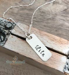 "Every mother loves to keep the names of her kids close to her heart. Give her this hand stamped sterling silver kids name necklace and she'll wear it for years to come. The perfect piece of mommy jewelry or a thoughtful gift for grandma! This personalized name tag necklace is made of: *Sterling silver tag, hand stamped with UP TO 8 LETTERS *Sterling silver jump ring *Sterling silver 18\" chain Take a look at some of my other personalized mom jewelry here! https://www.etsy.com/shop/EllenBKeepsak Silver Custom Name Charm Necklace For Everyday, Adjustable Hand Stamped Charm Necklace For Mom, Adjustable Hand Stamped Charm Necklace As Gift For Mom, Everyday Silver Charm Necklace With Custom Name, Silver Nickel-free Nameplate Necklace, Adjustable Silver Nickel-free Name Necklace, Adjustable Nickel-free Silver Name Necklace, Silver Name Charm Necklace For Everyday, Custom Name Silver Necklace For Everyday