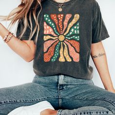 "Retro Groovy Flowers Shirt Vintage Shirt Boho Daisy Flower Tee Shirt Botanical Tee Boho Tee Wildflower Shirt Plant Shirt Botanical Shirt  Comfort Colors introduces the \"Comfort Colors 1717\" garment-dyed t-shirt; a fully customizable tee made 100% with ring-spun cotton. The soft-washed, garment-dyed fabric brings extra coziness to your wardrobe while the relaxed fit makes it an excellent daily choice. The double-needle stitching throughout the tee makes it highly durable while the lack of side-seams helps the shirt retain its tubular shape.  The Comfort Colors 1717 tee is made with medium fabric (6.1 oz/yd² (206.8 g/m consisting of high quality, 100% ring-spun US cotton for long-lasting comfort. The relaxed fit keeps the wearer comfy in both casual and semi-formal settings while the crew Camp Clothes, Groovy Flowers, Wildflower Shirt, Boho Tees, Botanical Shirt, Nice Clothes, Retro Groovy, Camping Outfits, Flower Shirt