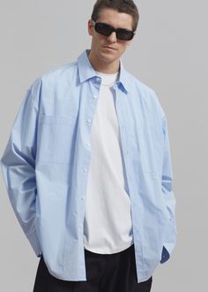 Color: Sky Crisp cotton poplin Oversized fit Pointed collar Double breast pockets Curved hem Front button closure Button cuffs 100% Cotton Dry Clean Imported One Size Spring Shirt With Fold Down Collar And Pockets, Spring Shirt With Pockets And Fold Down Collar, Blue Long Sleeve Shirt With Patch Pockets, Sky Blue Shirt, Blue Button-up Shirt With Patch Pockets, Oversized Collared Shirt With Patch Pockets, Oversized Cotton Shirt With Button Cuffs, Casual Oversized Shirt With Welt Pockets, Casual Long Sleeve Poplin Top