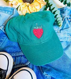 A embroidered strawberry on a green base ball cap. Cute Hats With Embroidered Logo And Curved Brim, Cute Baseball Cap With Embroidered Logo And Curved Brim, Casual Embroidered Trucker Hat With Short Brim, Casual Trucker Hat With Embroidered Short Brim, Trendy Cotton Hat With Curved Brim, Cute Cotton Baseball Cap With Curved Brim, Spring Novelty Hats With Curved Brim, Cute Cotton Curved Brim Baseball Cap, Cute Cotton Baseball Cap