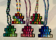 four necklaces with words on them that say eat sleep, rave, repeat and keep calm