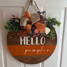 a wooden sign that says hello pumpkin hanging on a door with burlocks and leaves