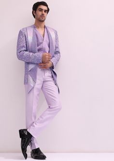 Elevate your evening ensemble with our expertly crafted three-piece tuxedo set. Crafted on a glamorous shimmer base. This lavender tuxedo is ornate with hand embroidered cutdana work and lapel detailing. Complemented with a pleated shirt and straight pants. This glitzy outfit will command everyone's attention. Dry-clean only if required. Slight variation in color is possible due to digital photography. Glamorous Tailored Wedding Suits, Fitted Sherwani For Festive Spring Occasions, Spring Festive Fitted Sherwani, Designer Fitted Sherwani For Spring, Fitted Bandhgala For Festive Spring Occasions, Festive Evening Tuxedo Sets, Fitted Bandhgala For Festive Evenings, Purple Tuxedo Suit For Wedding, Fitted Purple Tuxedo For Party