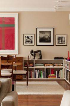 a living room filled with lots of furniture and pictures on the wall above it's bookshelf