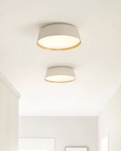 two lamps are hanging from the ceiling in a room with white walls and flooring