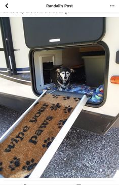 a dog is sitting in the open door of a camper