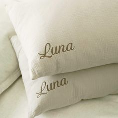 two pillows with the words lunaa and lunaa written on them in cursive font