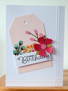 a happy birthday card with flowers and a tag on the front that says happy birthday