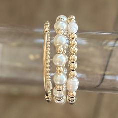 Show off your classic style with this chic bracelet stack of gold and pearls! Each bracelet has its own unique shimmer that is sure to have heads turning. Add a little oomph to your look with this classic yet stylish combo of pearls and gold! Kate- (73732400) 4mm gold filled beads with gold filled bar 5mm gold filled alternating with round cream pearls 5mm gold filled beads with natural freshwater pearls HOC-Spring/Autumn Classic Gold Bracelet With Pearl Drop, Classic Gold Pearl Beaded Bracelets, Adjustable Stackable Pearl Bracelet, Adjustable Pearl Beaded Bracelets Stackable, White Stackable Bracelets For Party, Adjustable Stackable Pearl Beaded Bracelets, Classic Gold Pearl Bangle Bracelet, Gold Pearl Bracelet For Party, Elegant Silver Bracelets With Gold Beads