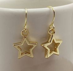 Minimalist Gold Star Earrings Small Star Earrings Gold Dangle Open Star Earrings Small Gold Star Charms dangle from minimalist gold filled ear wire. Very simple, yet impactful, in design. These Open Star Earrings are certain to become your favorite accessory. Your Star Earrings will arrive in an organza pouch with a matching polishing cloth. Gift packaging and gift card cheerfully provided upon request! Hanging Star Earrings, Minimalist Gold Jewelry Earrings, Gold Star Earrings Aesthetic, Star Gold Jewelry, Gold Star Jewelry Aesthetic, Gold Star Accessories, Simple Gold Dangle Earrings, Star Earrings Gold, Dangly Gold Earrings