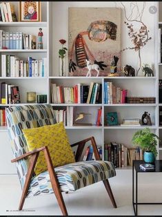 a living room filled with lots of furniture and bookshelves full of books on top of them