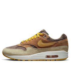 The Nike Air Max 1 Premium 'Ugly Duckling Pecan' is a stylish sneaker that is perfect for everyday wear. It features a brown leather upper with a yellow Swoosh, and a rubber sole for extra traction. The inspiration behind the design comes from the Baroque era, with the layered brown and beige leather covering the midfoot and mudguard. The yellow Swoosh and embroidered duck on the heel complete the look. This sneaker is suitable for a variety of activities, from running errands to going out with friends. (SNKR/Retro/Unisex/Low Top) Brown Boost Midsole Sneakers For Streetwear, Brown Sneakers With Boost Midsole For Streetwear, Brown Suede Sneakers For Streetwear, Brown Low-top Custom Sneakers With Boost Midsole, Urban Brown Sneakers For Streetwear, Brown Urban Sneakers For Streetwear, Brown Sports Sneakers With Rubber Sole, Brown Sneakers With Boost Midsole And Round Toe, Brown Sporty Custom Sneakers With Rubber Sole