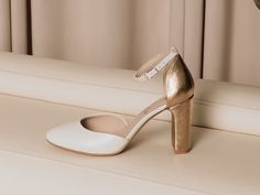 a pair of white high heeled shoes sitting on top of a table