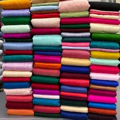 a large stack of folded and unbuttoned towels on display in a store