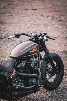 a black motorcycle parked on top of a dirt field