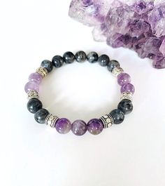 "Amethyst and Labradorite Bracelet, Amethyst Bracelet, Labradorite Bracelet, Gemstone Bracelet This lilac purple and dark gray bracelet is an eye-catching unique gemstone combination that is complimented with antique silver Tibetan spacer beads. 8mm Amethyst and Labradorite are strung on a strong stretch cord for a comfortable fit for your wrist.  The calming stone of amethyst is a natural stress reliever and is said to promote balance, peacefulness, contentment, and happiness. This semi-precious stone is known to calm and soothe the mind and emotions. Wearing an amethyst bracelet is a great way to carry the calming energy around with you wherever you go. Labradorite is known as the \"stone of transformation\" is said to help those seeking knowledge and guidance to find answers. It is exce Lavender 8mm Beads Jewelry For Healing, Lavender Spiritual Jewelry With 8mm Beads, Spiritual Lavender Jewelry With 8mm Beads, Lavender Spiritual Jewelry With Beads, Amethyst Stretch Bracelet With 8mm Beads As Gift, Black Amethyst 8mm Bead Bracelets, Black Amethyst Bracelets With 8mm Beads, Black Amethyst Bracelet With 8mm Beads, Lavender 8mm Beads Bracelet Gift