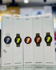 three samsung smart watches are displayed in their packaging boxes, one is for sale and the other is for sale