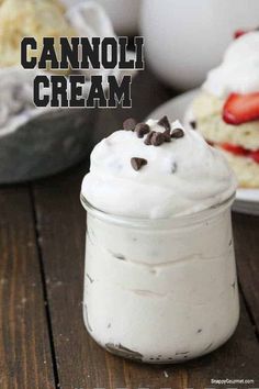 a jar filled with whipped cream next to cookies and other desserts on a table