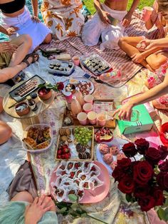 a group of people sitting around a table filled with food