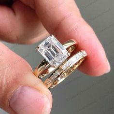 a person holding two wedding rings in their hand, one with a diamond and the other with an engagement ring