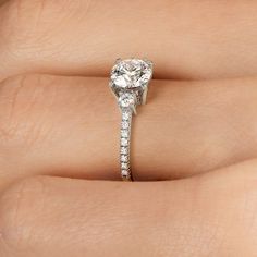 a woman's hand holding an engagement ring with a diamond in the shant