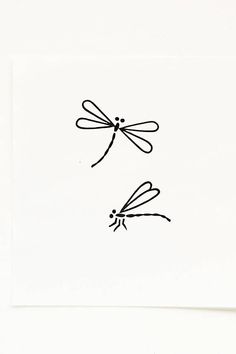 a drawing of two dragonflies on a white paper with the numbers 1 - 2