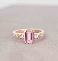 a pink tourmaline and diamond ring sitting on top of a table