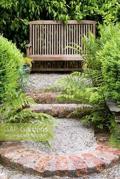 a wooden bench sitting in the middle of a garden