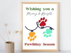 a dog paw print hanging on a wall next to a vase