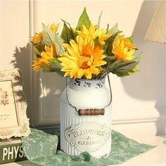 there is a vase with flowers in it next to a framed photo and an old book