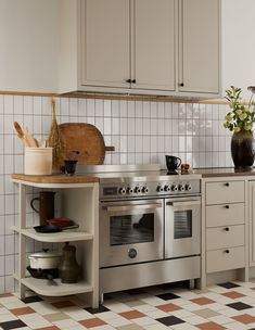 a stove top oven sitting inside of a kitchen next to a counter with pots and pans on it