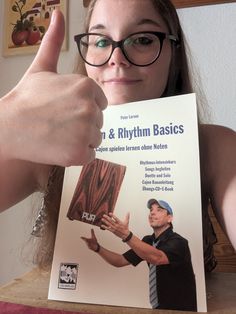 a woman is holding up a book with an image of a man's hand