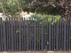 a black fence is shown in front of some trees